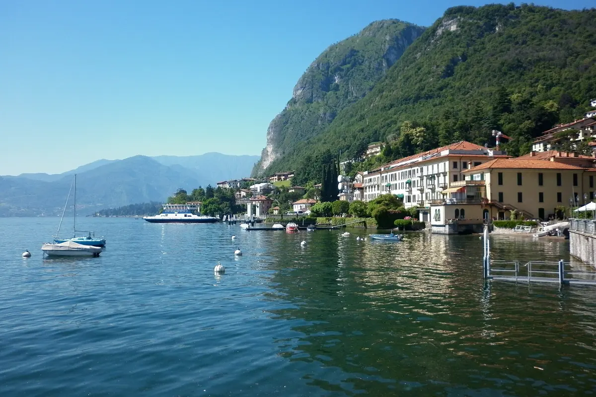 Menaggio's waterfront seen across Lake Como with mountains behind it